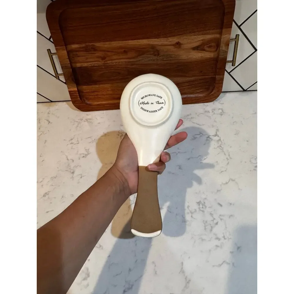 white ceramic spoon rest black bee graphic contrasting brown dipped handle